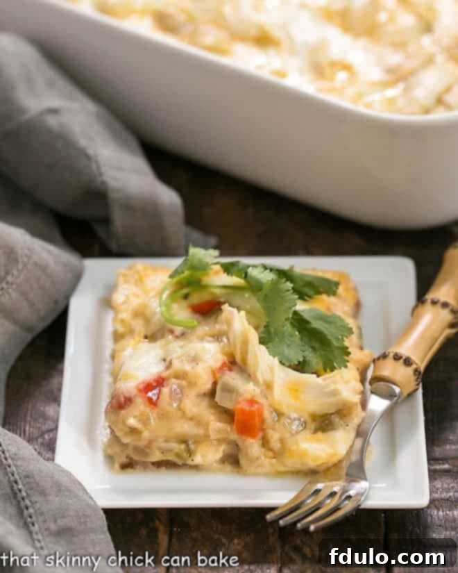 King Ranch Casserole from Scratch on a white plate with a sprig of cilantro, showcasing its rich, cheesy topping and vibrant Tex-Mex flavors.