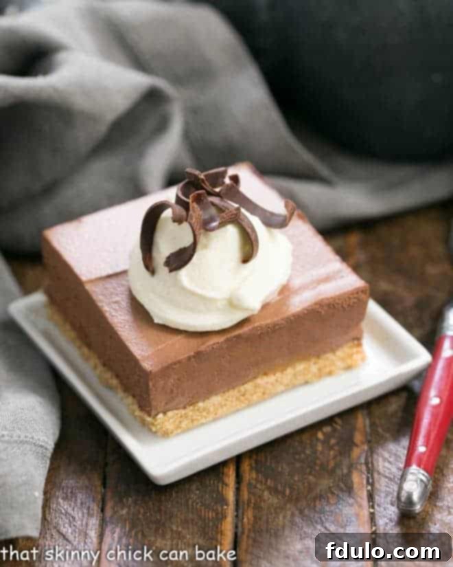 Easy chocolate mousse bars on a white plate with cream and chocolate shavings.