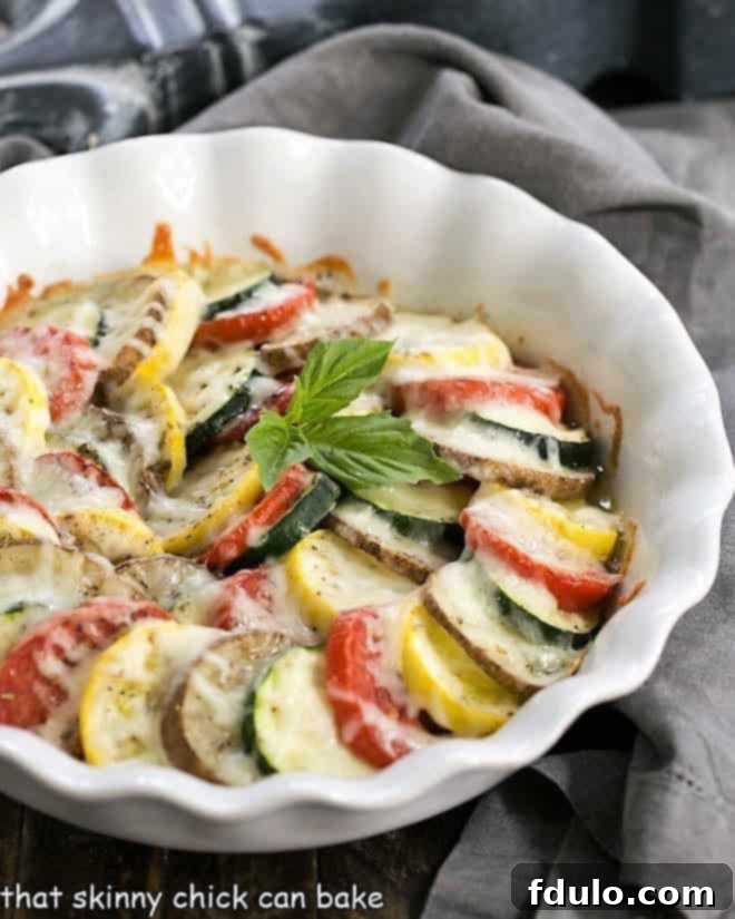 Cheesy Vegetable Tian in a white pie plate, showcasing vibrant layers of vegetables