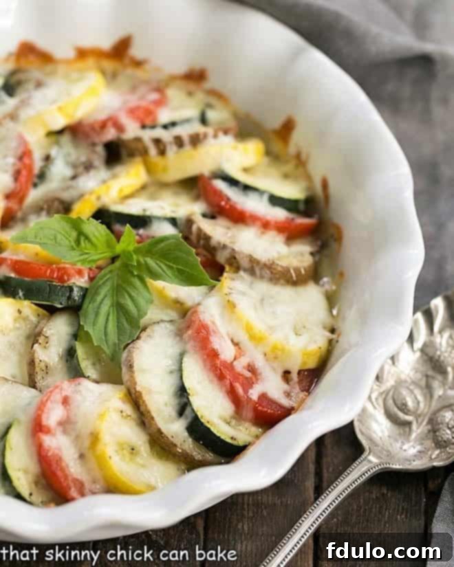 Cheesy Vegetable Tian baked in a fluted white pie plate, showing golden-brown cheese topping