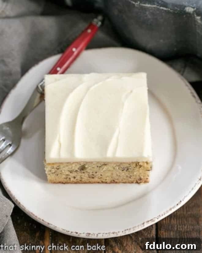 An overhead shot of a delightful slice of Sour Cream Banana Cake on a white plate, highlighting the rich frosting.