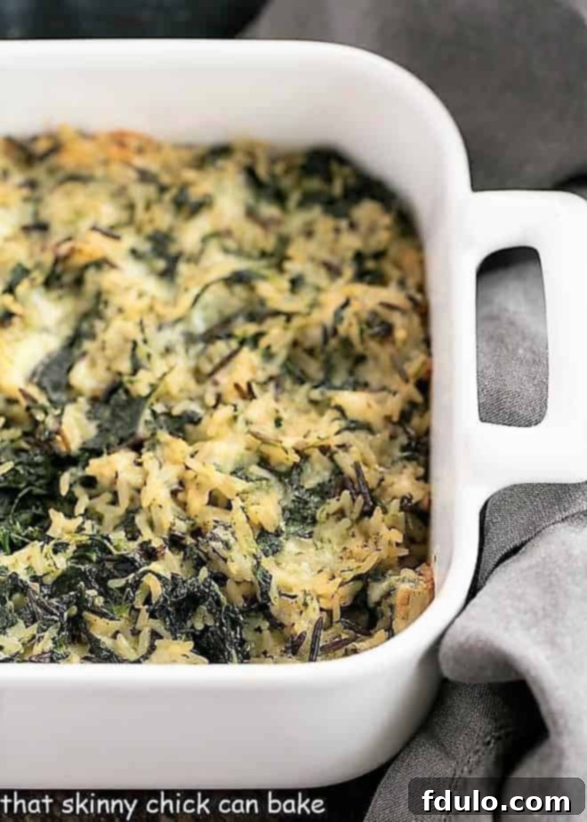 A golden brown Cheesy Spinach Rice Casserole baked in a white ceramic dish, ready to be served.
