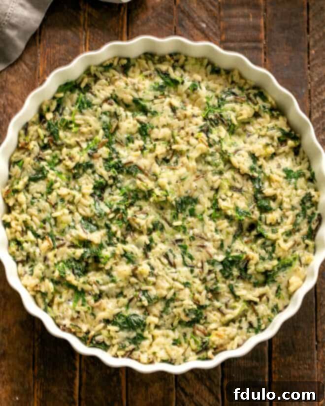 The Cheesy Spinach Rice Casserole mixture fully combined in a bowl, ready to be transferred to a baking dish.