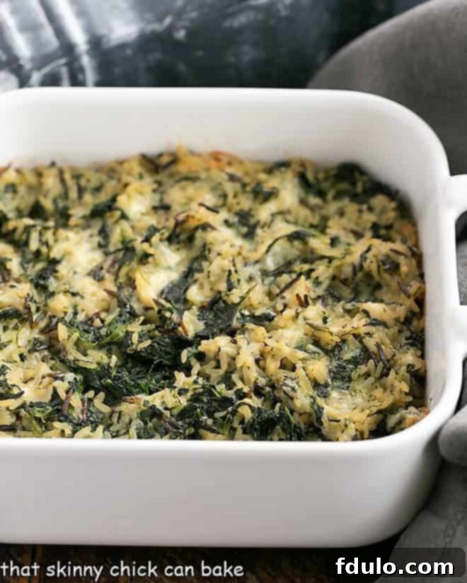Cheesy Spinach Rice Casserole baked in a square casserole dish with a golden crust.