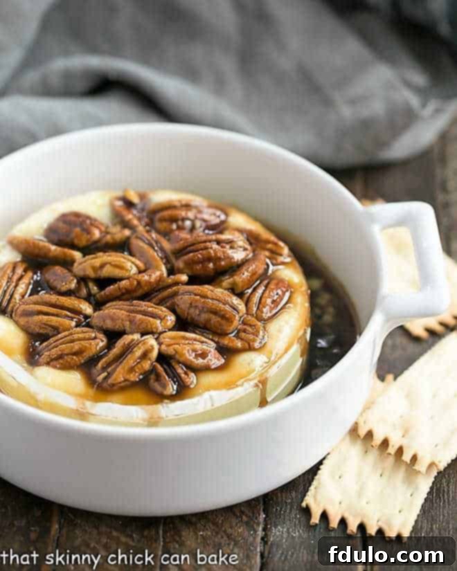 Kahlua Caramel Brie Indulgence 2 Kahlua Caramel Baked Brie in a small white casserole dish, garnished with pecans.