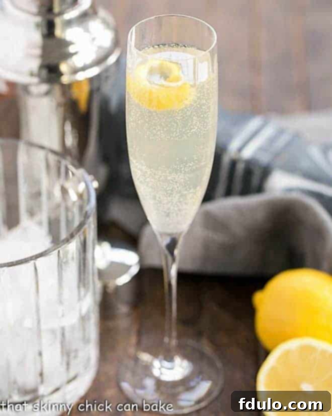 A vibrant French 75 Champagne Cocktail in a tall champagne flute, ready for a celebration.