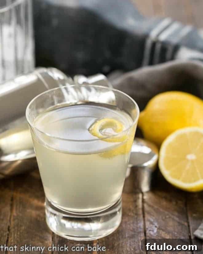 A refreshing French 75 Champagne Cocktail with a lemon twist, served in a classic highball glass.