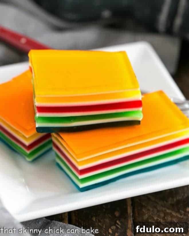 Jello Rainbow Ribbon Salad slices on a square white plate