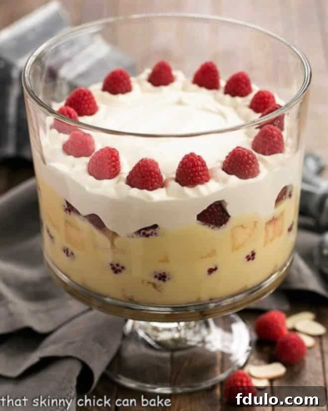 Christmas Trifle - a classic British dessert with layers of cake, creme anglaise, raspberries, jam and whipped cream Traditional English Trifle topped with whipped cream and fresh raspberries, close-up shot.