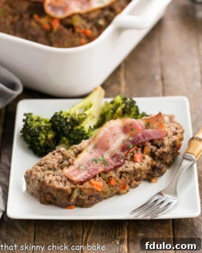 Master the Art of Homemade Meatloaf: Tips for a Perfect, Flavorful Dish A perfectly sliced piece of homemade meatloaf, glistening with glaze, served on a white plate. Learn how to make the best meatloaf.