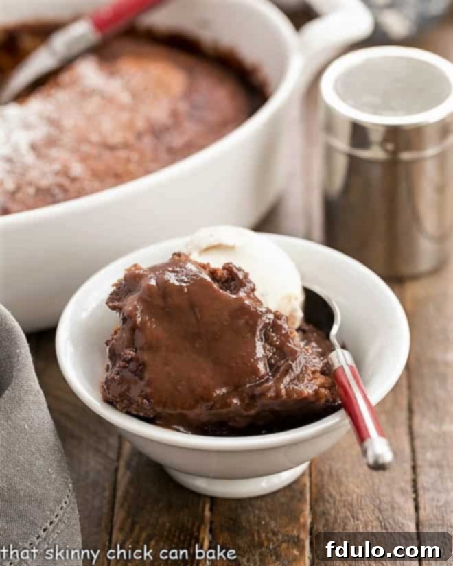 Simple Chocolate Pudding Heaven 2 Easy Chocolate Pudding Cake in a bowl with a spoon and a scoop of ice cream, showcasing the layers.