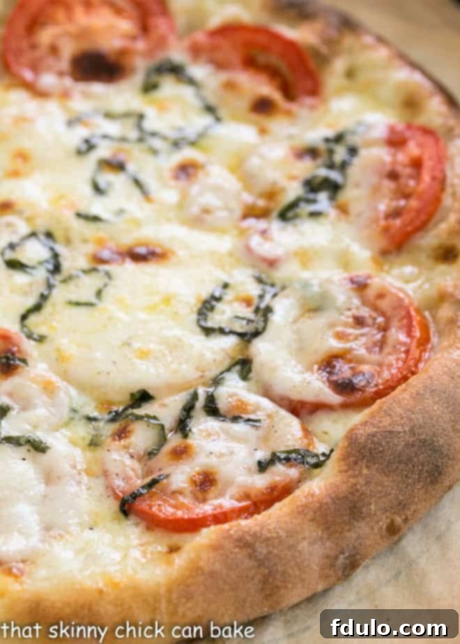 Close view of elastic homemade pizza dough on a sheet of parchment, ready to be shaped
