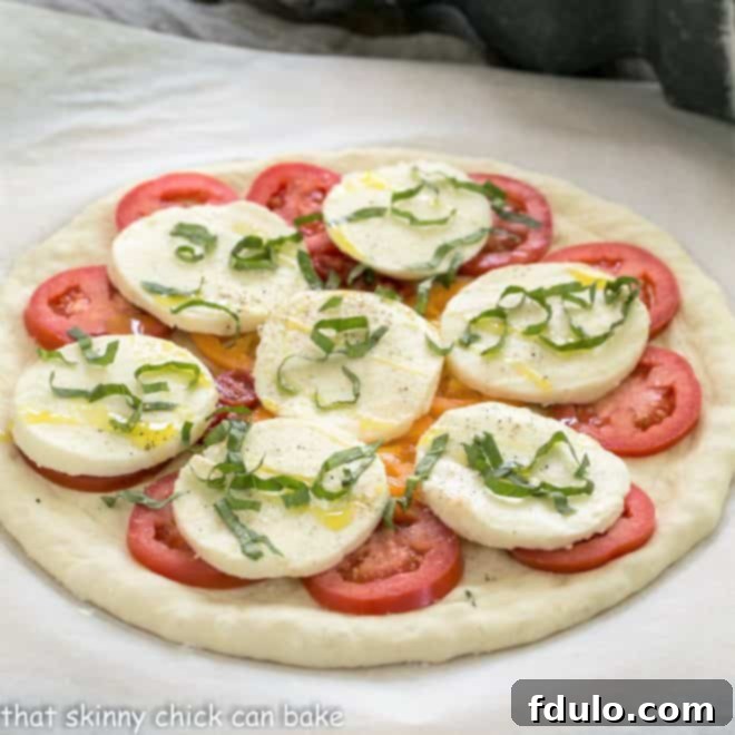 Uncooked classic pizza dough with Margherita toppings ready for the oven