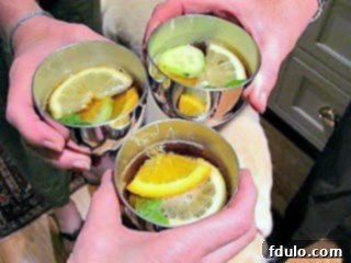Toasting with Pimm's Cup in traditional pewter cups, garnished with fresh fruit and mint.