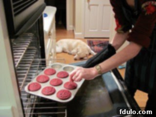 Freshly baked Red Velvet Cupcakes adorned with luscious Cream Cheese Frosting, just out of the oven, exuding warmth and deliciousness.