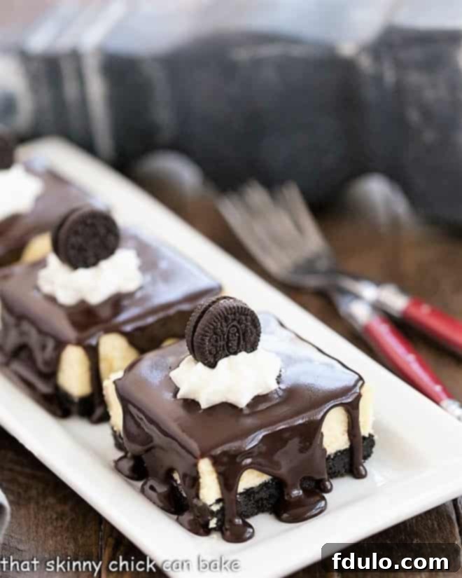 Hot Fudge Cheesecake Bars on a white platter, ready to be served, with elegant red-handled forks nearby.