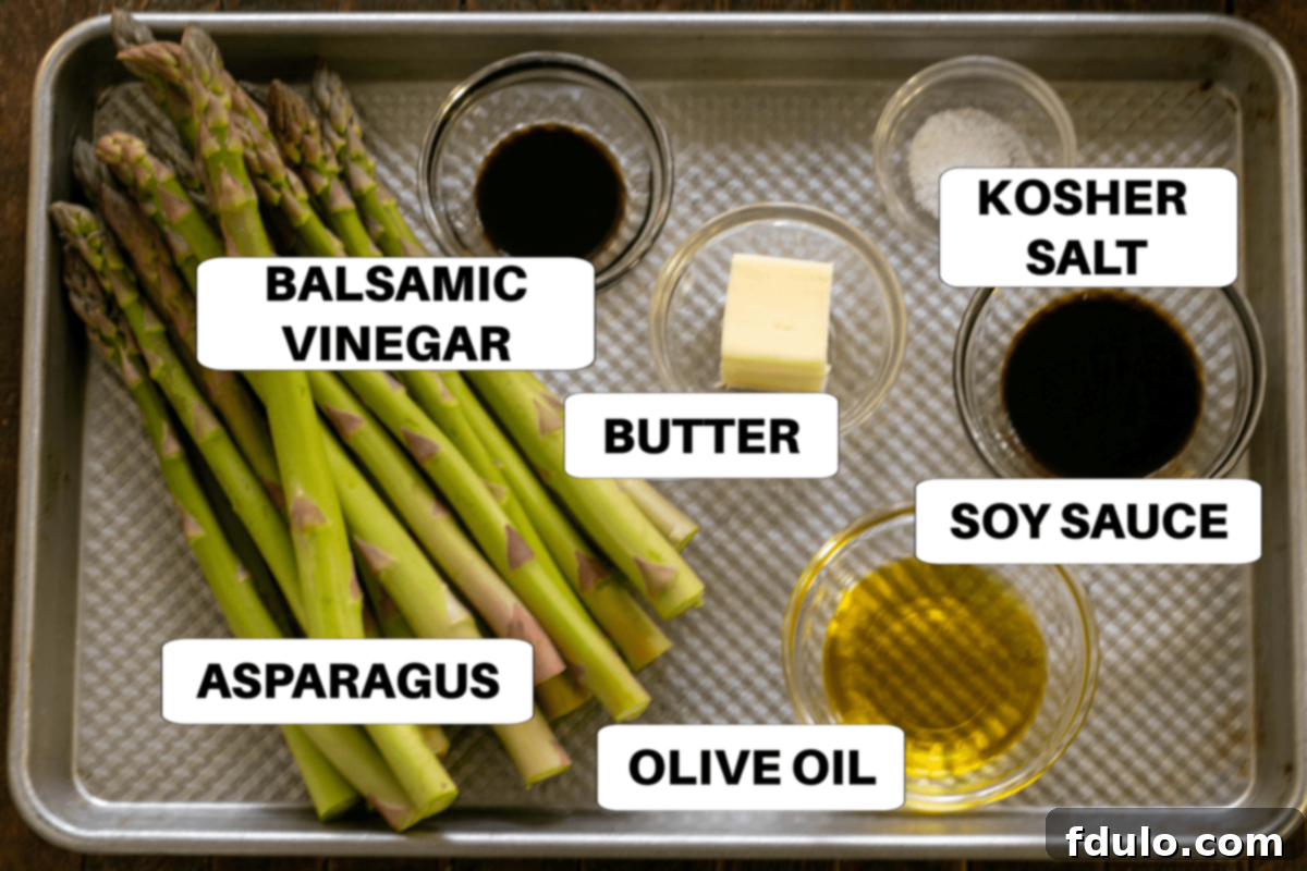 Roasted Asparagus with Balsamic Brown Butter Ingredients laid out on a sheet pan with labels, including fresh asparagus, olive oil, salt, butter, soy sauce, and balsamic vinegar.