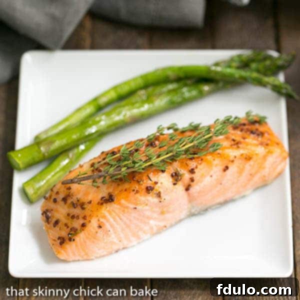 A perfectly cooked Maple Mustard Glazed Salmon fillet presented on a sleek white square plate.