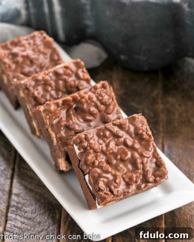 Peanut Butter Krispie Topped Brownies on a white platter, showcasing the three delicious layers