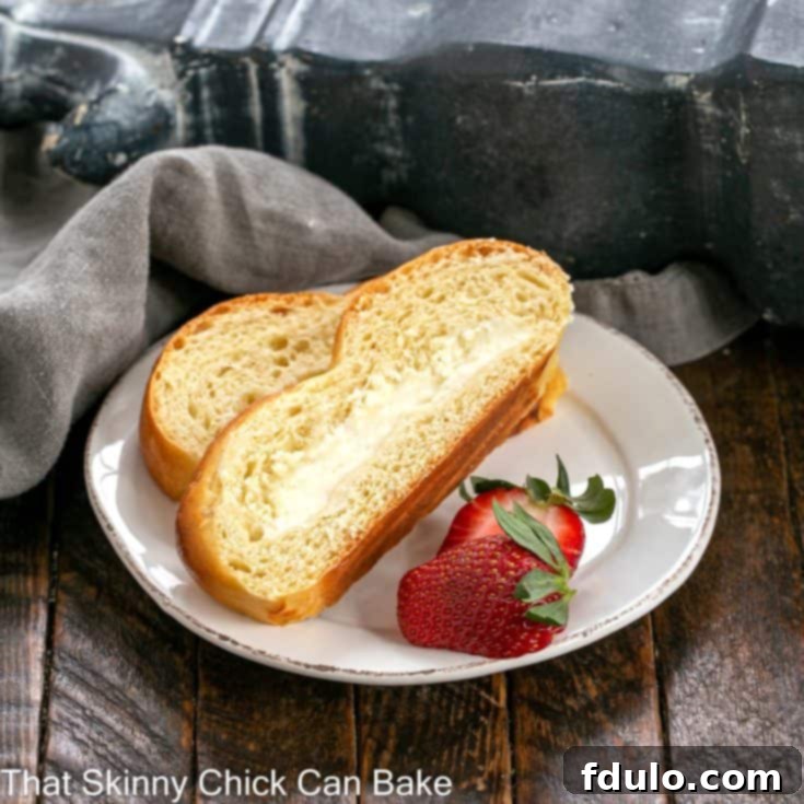Two slices of braided Easter bread with a creamy cream cheese filling, presented on a small white plate, ready to be enjoyed.