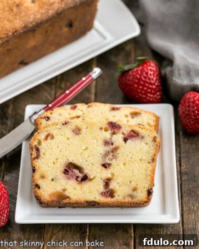 Fresh Strawberry Pound Cake - Dense, delicious, with sweet bits of fresh strawberries! Slices of Fresh Strawberry Pound Cake arranged on a square white ceramic plate with a red-handled knife resting beside them, showcasing the dense texture and visible strawberry pieces.