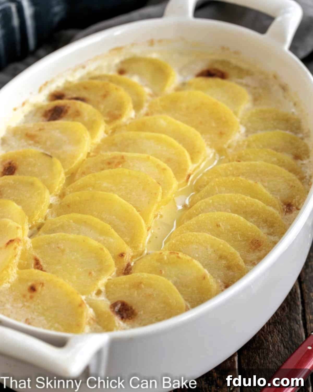 Oval casserole dish of scalloped potatoes.