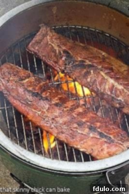 Two racks of Fall Off the Bone Baby Back Ribs being grilled for initial browning.