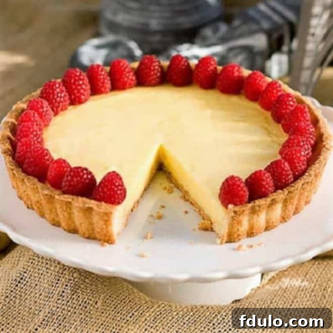  Tarte au Citron AKA French Lemon Tart on a cake stand with a slice removed.