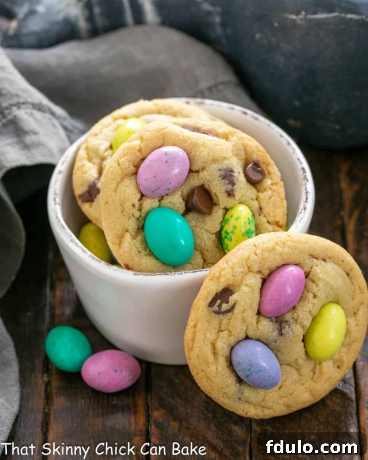Easter cookies in a white bowl with one leaning on the bowl.