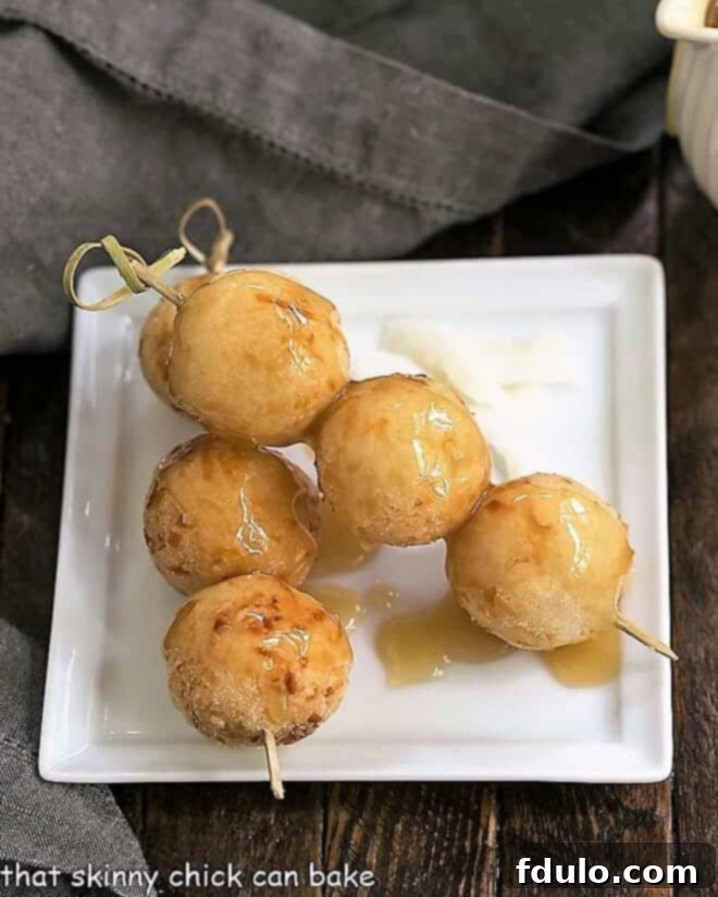 Carioca or Fried Sticky Rice Balls - a Filipino treat with a triple dose of coconut including the drizzle of decadent coconut caramel sauce! Carioca or Fried Sticky Rice Balls delicately threaded onto wooden skewers, artfully arranged on a square white plate, highlighting their snack-sized appeal and making them perfect for sharing.