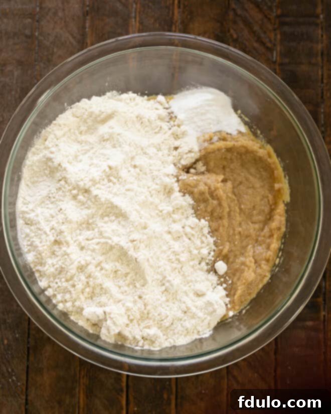 Dry ingredients (flour, baking soda, salt) being gently stirred into the wet mixture.