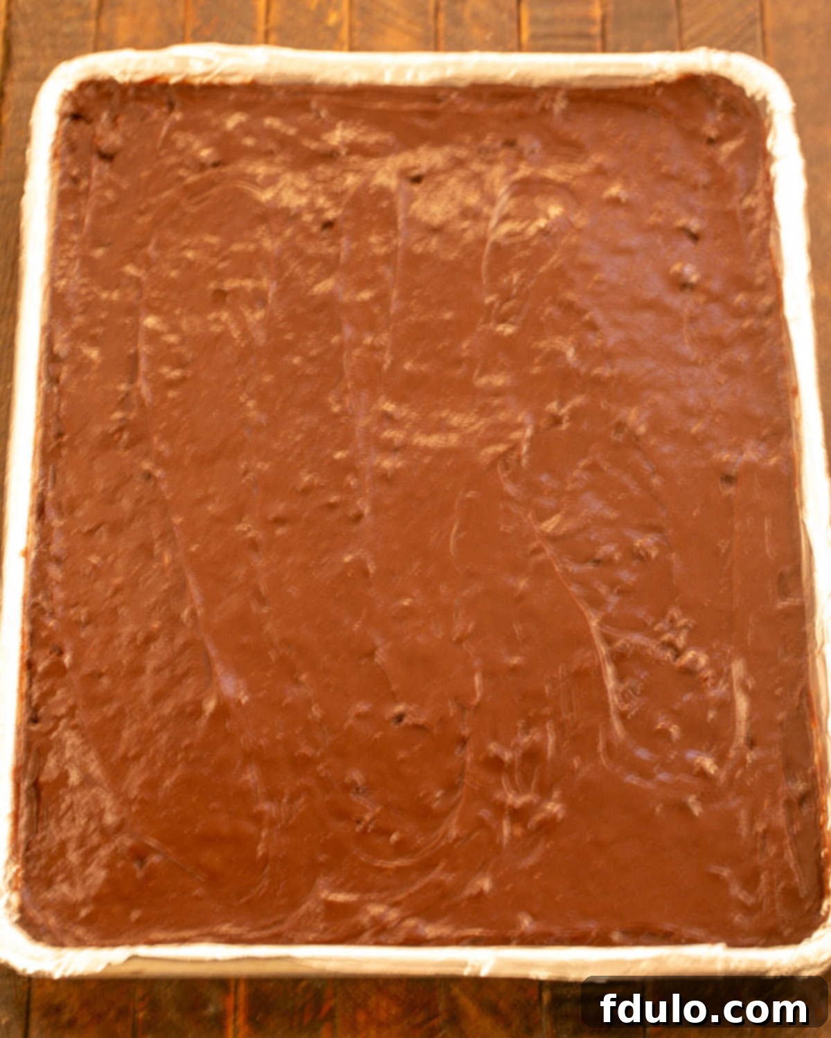 Step 9: Brownie batter spread evenly in a sheet pan with an offset spatula.