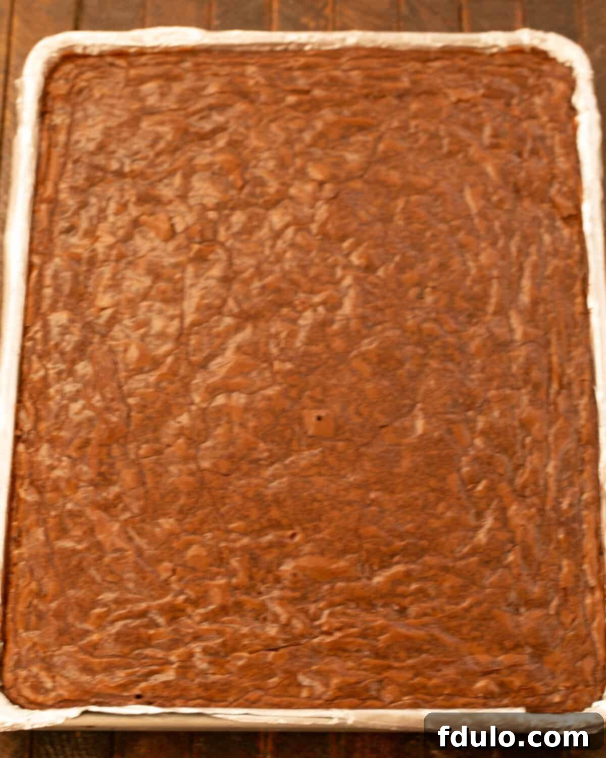 Step 10: Baked sheet pan brownies cooling in the pan, showing the shiny crust.