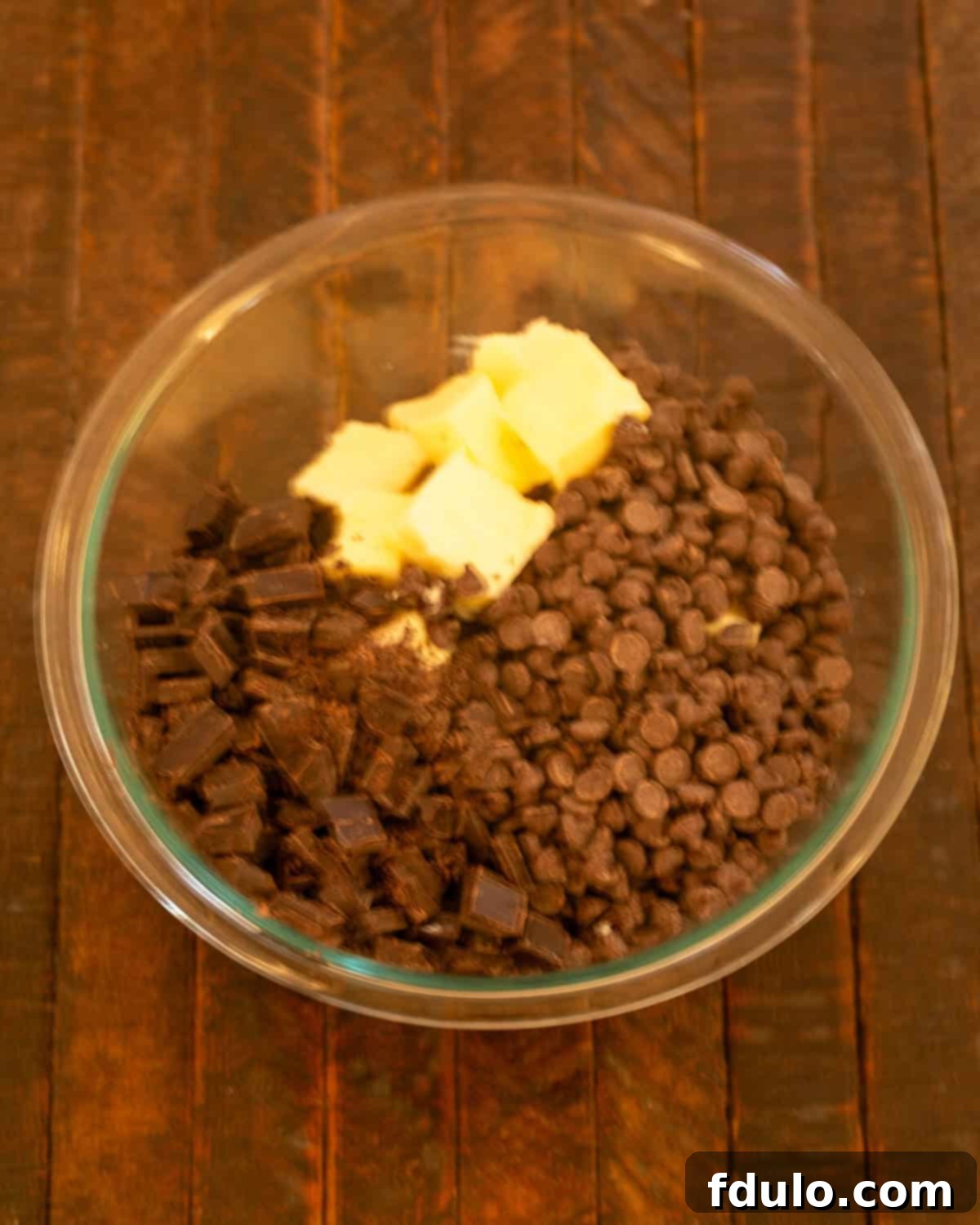 Step 1: Butter, chocolate chips, and chopped unsweetened chocolate in a heatproof bowl.