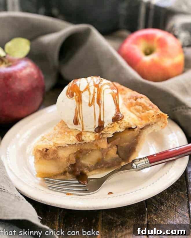 Caramel Apple Pie - a fabulous homemade apple pie enhanced by caramel sauce added to the filling! Slice of Caramel Apple Pie on a white plate with a red handled fork.