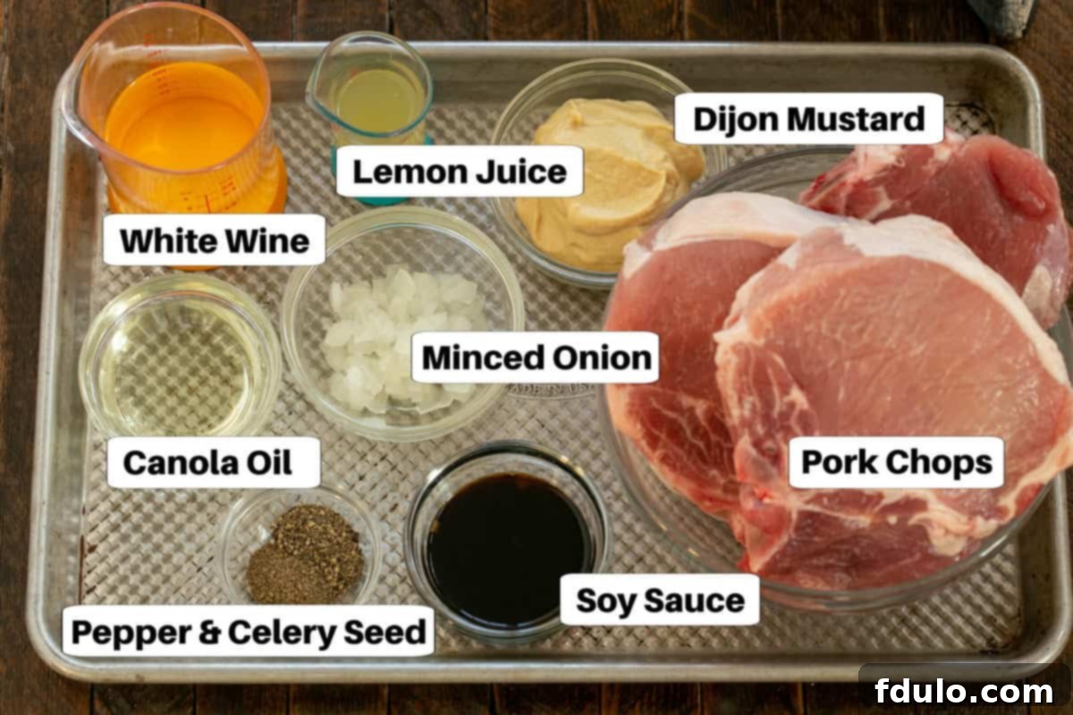 Marinated Pork Chops ingredients with labels on a sheet pan, showcasing fresh, high-quality components.