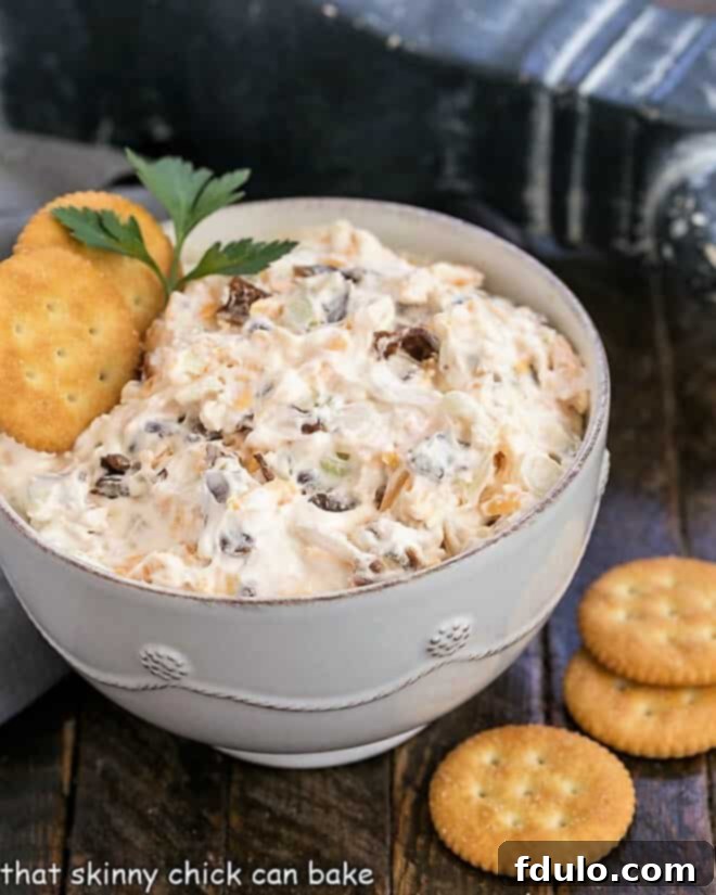 Bacon Cheddar Dip in a white bowl with butter crackers, ready to be served at a party.
