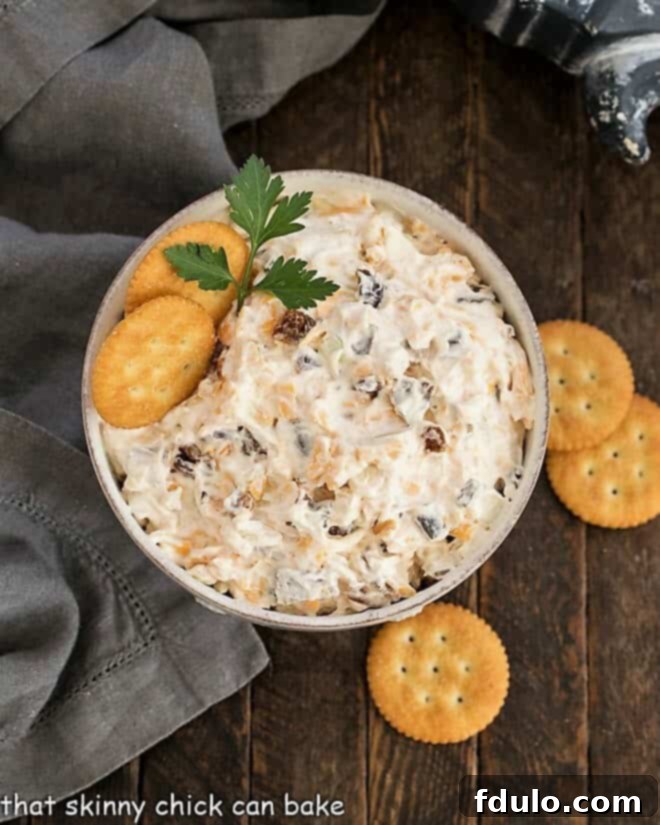 Overhead view of Bacon Cheddar Dip in a white serving bowl with crackers around it, ready for a party.