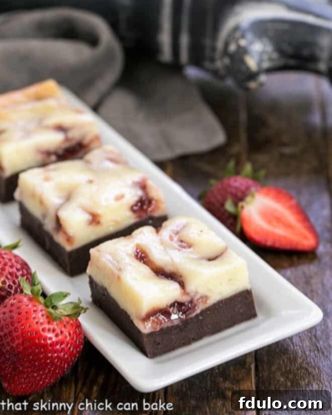 Decadent Strawberry Cheesecake Brownies on a rectangular white tray, showcasing their rich fudgy base and vibrant strawberry-swirled cheesecake topping.