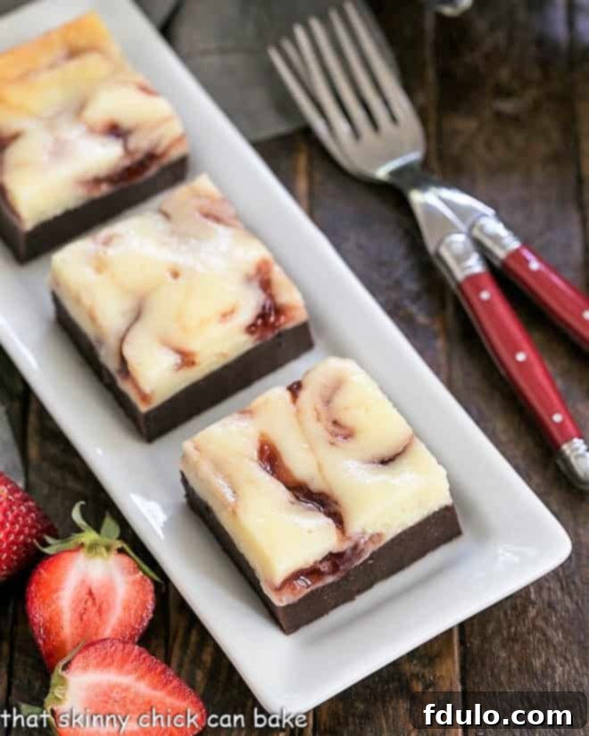 Overhead view of perfectly cut Strawberry Cheesecake Brownies on a white tray, showcasing their layers and swirl.