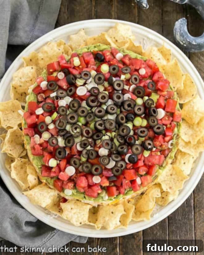 Overhead view of Layered Taco Dip surrounded by tortilla chips.