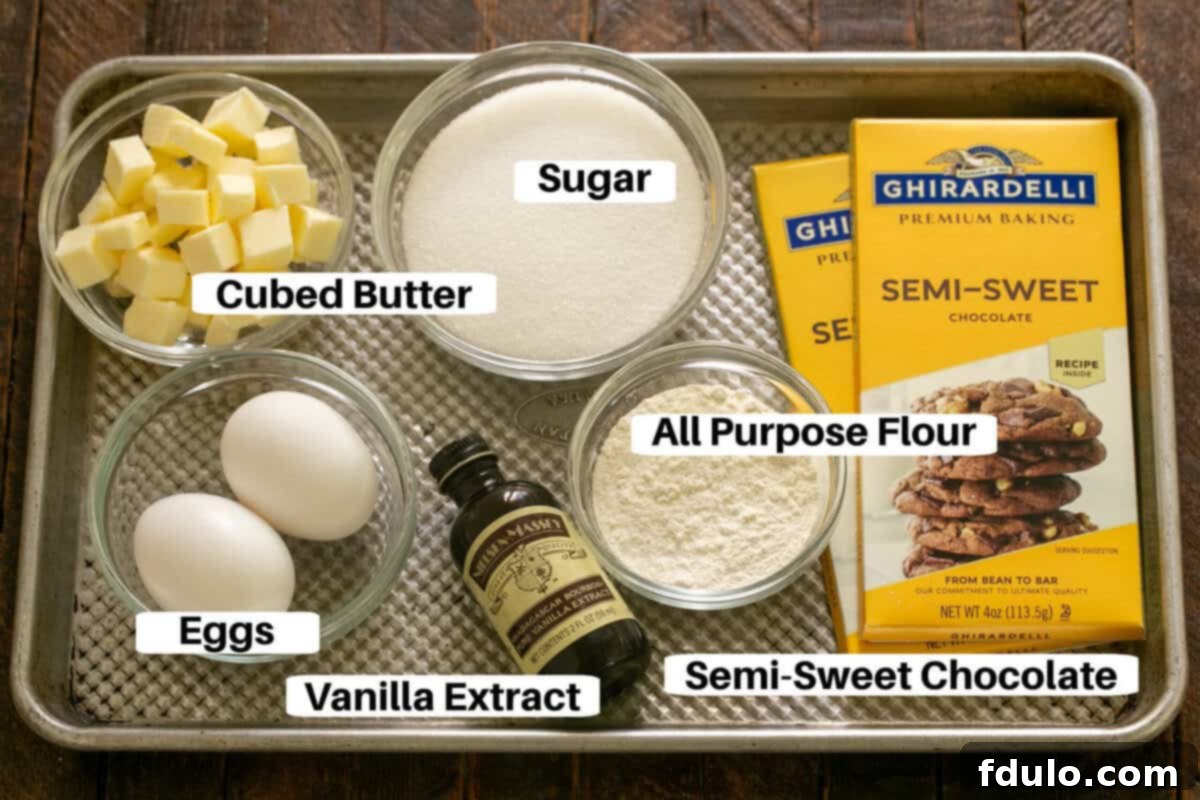 Overhead shot of all the fudgy brownie ingredients, neatly arranged with labels on a sheet pan, ready for baking.