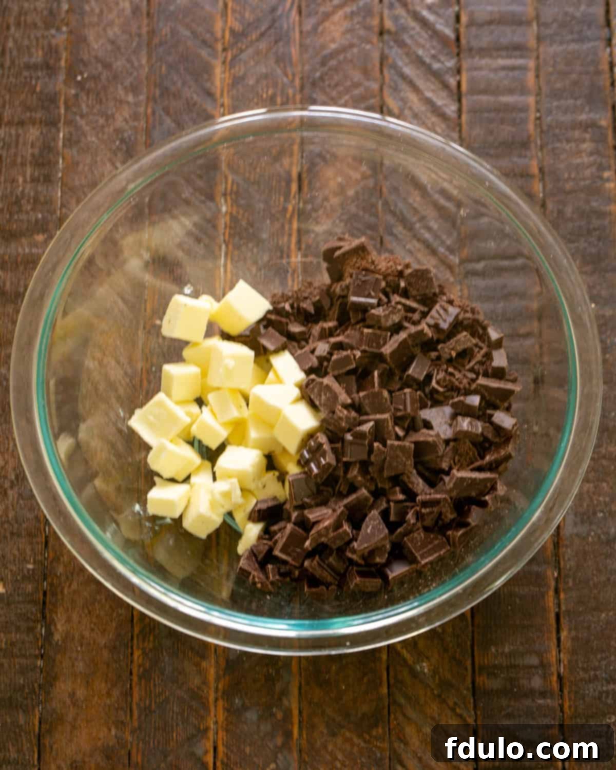 Step-by-step image showing chocolate and butter melting gently in a microwave-safe bowl.