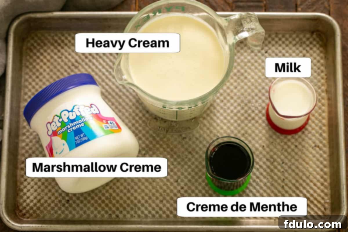 Ingredients for the mint filling, including marshmallow creme, heavy cream, milk, and creme de menthe, displayed on a metal sheet pan.