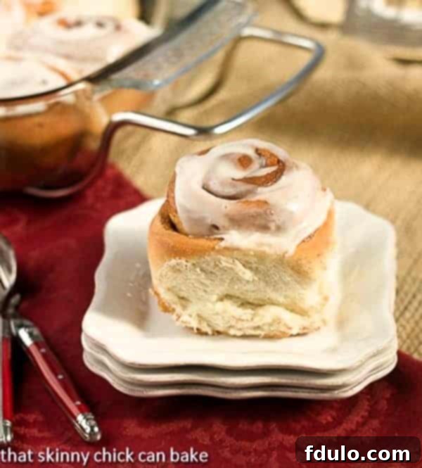 A stack of freshly baked, tender Moomie's Cinnamon Buns with generous vanilla glaze, ready to be served.