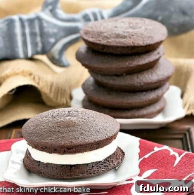 Chocolate Whoopie Pies - The ultimate Whoopie Pies recipe featuring an exquisite marshmallow cream filling Classic Whoopie Pies arranged neatly on white dessert plates, showcasing their perfect rounded shape and creamy filling.