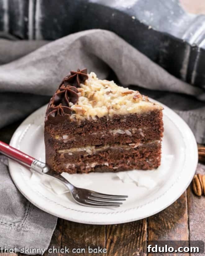 Slice of German Chocolate Cake on a dessert plate with a red fork, showcasing its layers and delicious filling.
