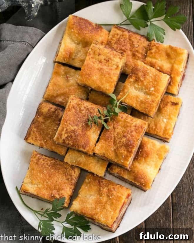 Overhead view of Antipasto Squares on a white oval platter, ready to be served.