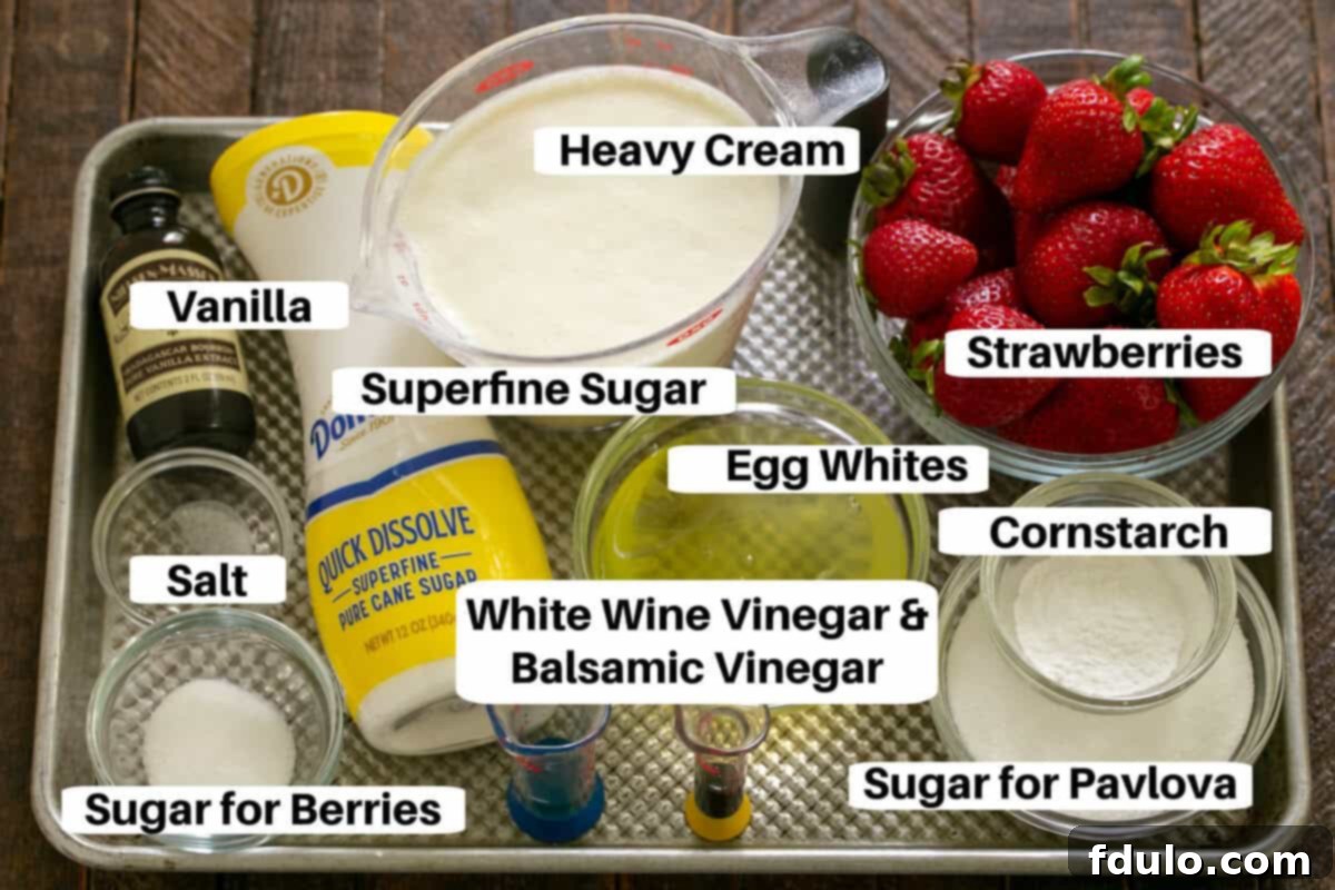 All the fresh ingredients for Strawberry Pavlova, including egg whites, sugar, cornstarch, vinegars, vanilla extract, fresh strawberries, and heavy whipping cream, arranged on a metal sheet pan.