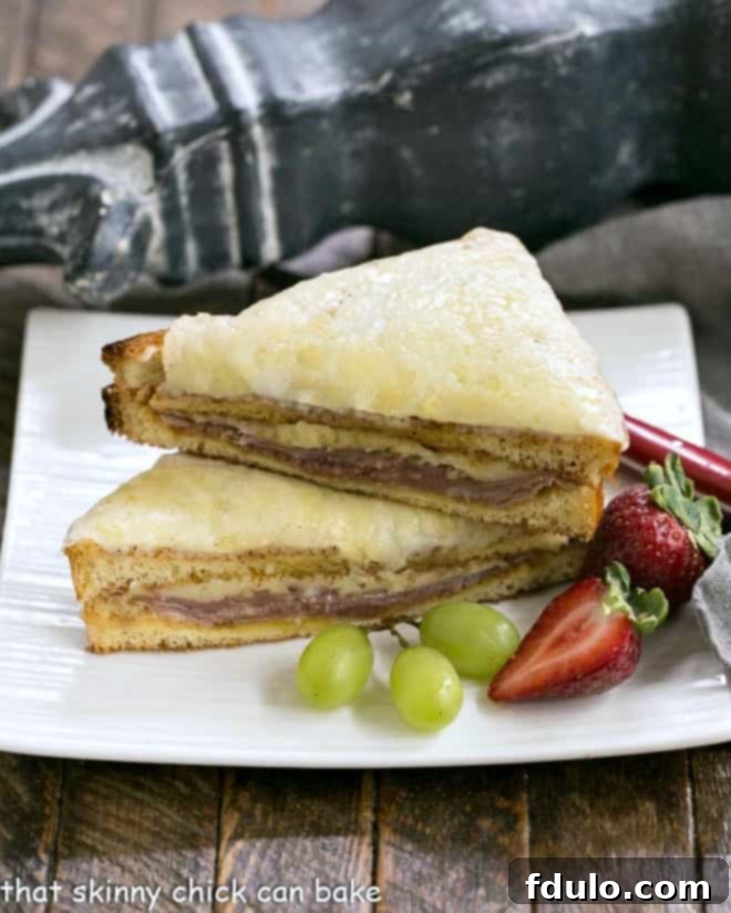 A perfectly assembled classic French Ham and Cheese Sandwich, known as a Croque Monsieur, elegantly stacked on a square white plate, ready to be enjoyed.